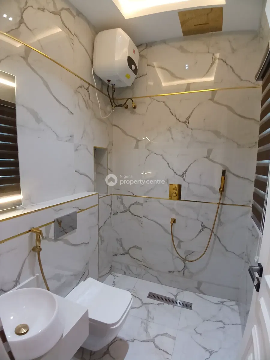 Bathroom with marble-patterned walls and gold-toned shower fitting