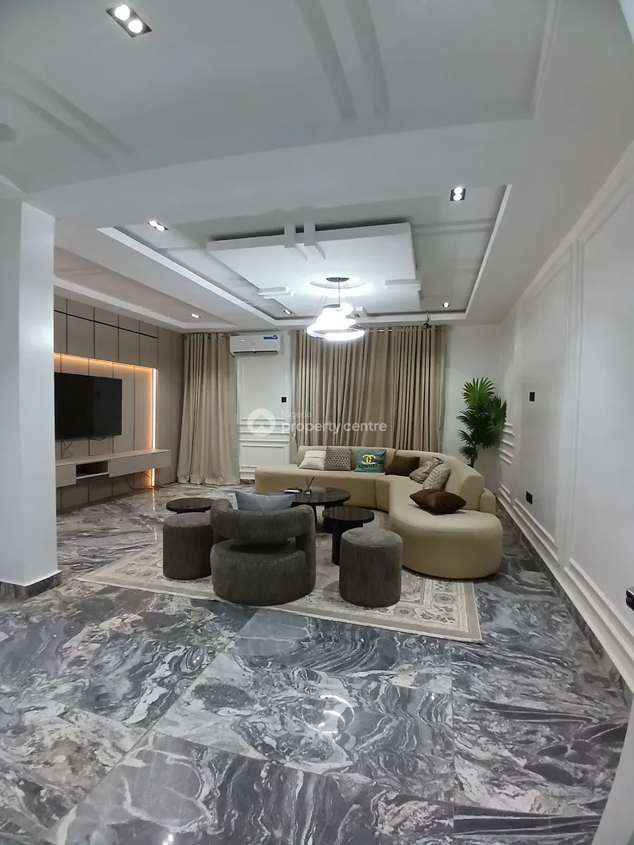 Furnished main lounge with layered ceiling and marble-patterned floor