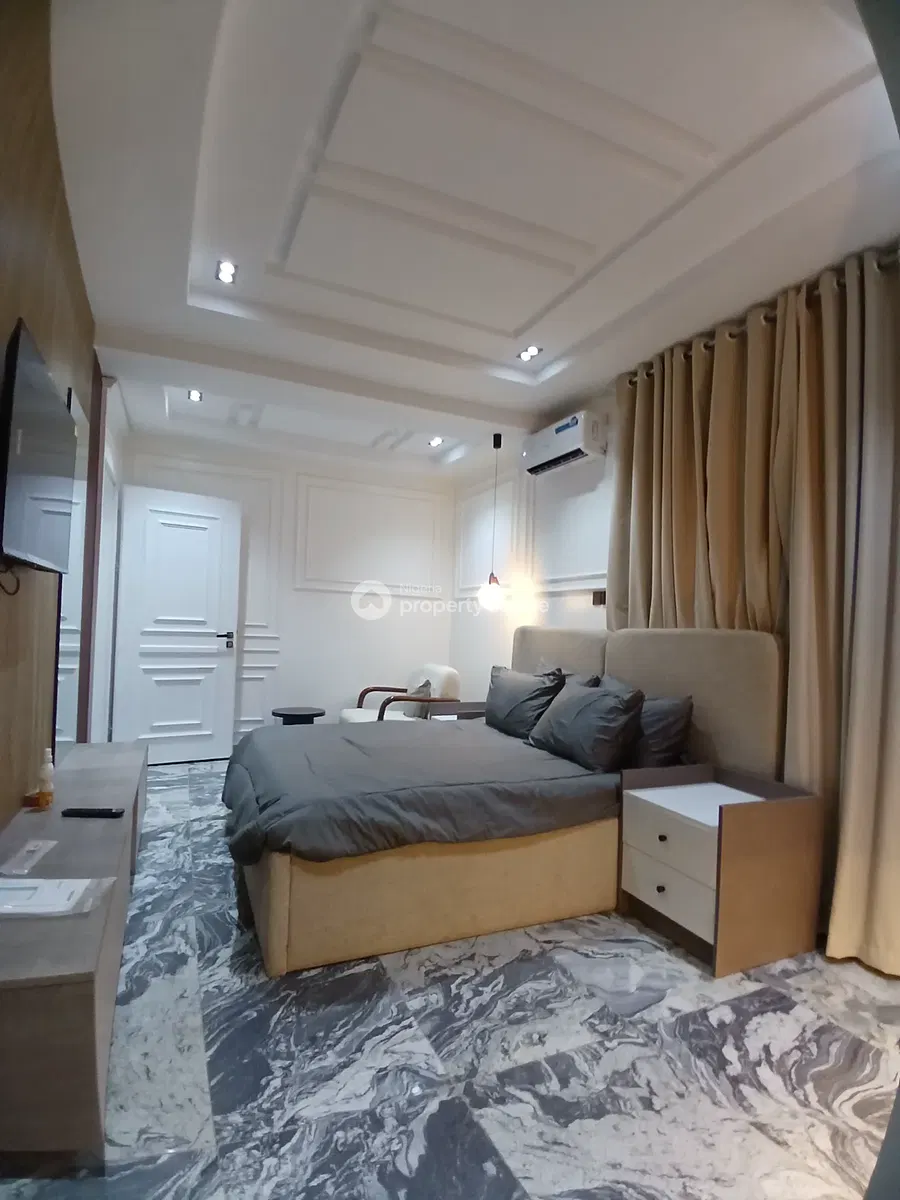 Bedroom with grey bedding, desk and curtains