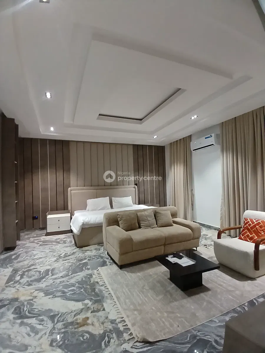 Furnished bedroom with bed, sofa seating and patterned floor