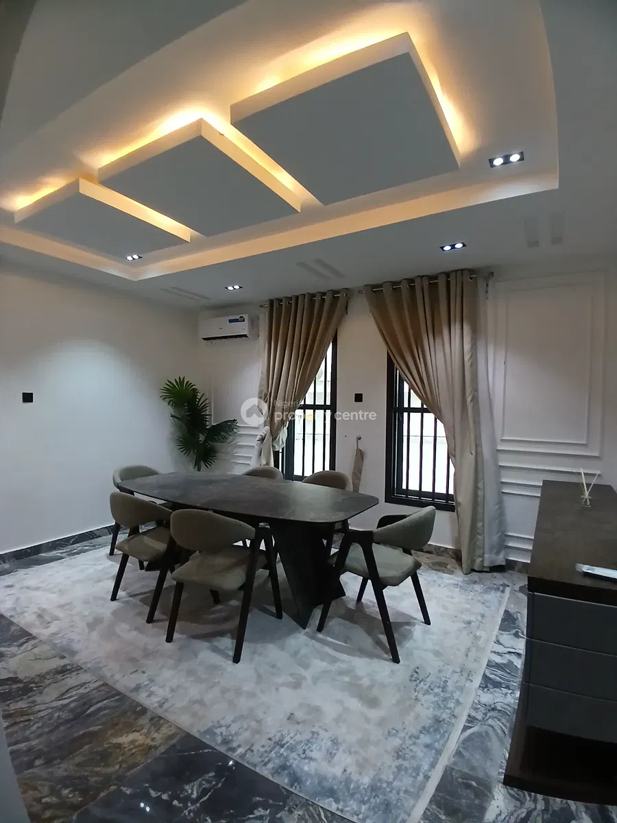 Dining table beneath warm geometric ceiling lighting