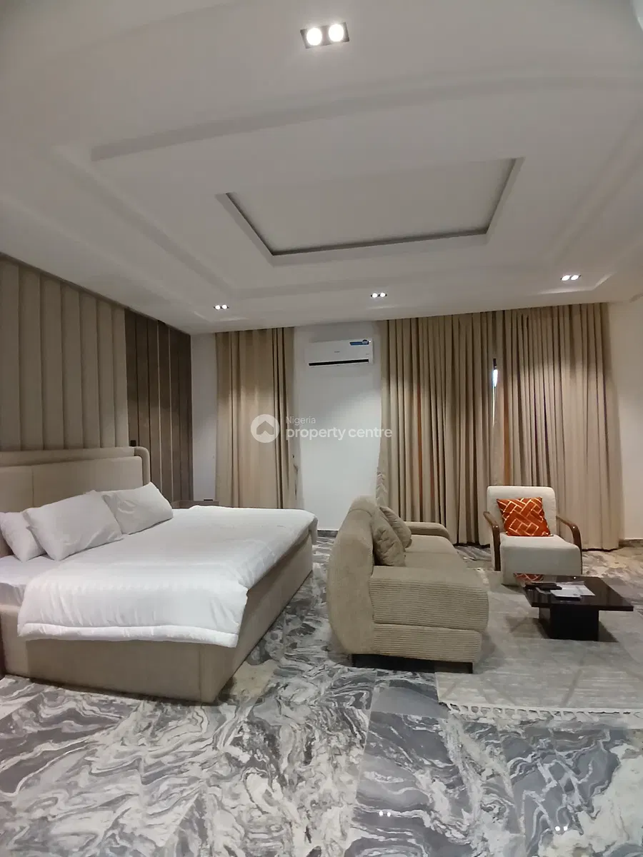 Side view of a bedroom with bed and sofa seating